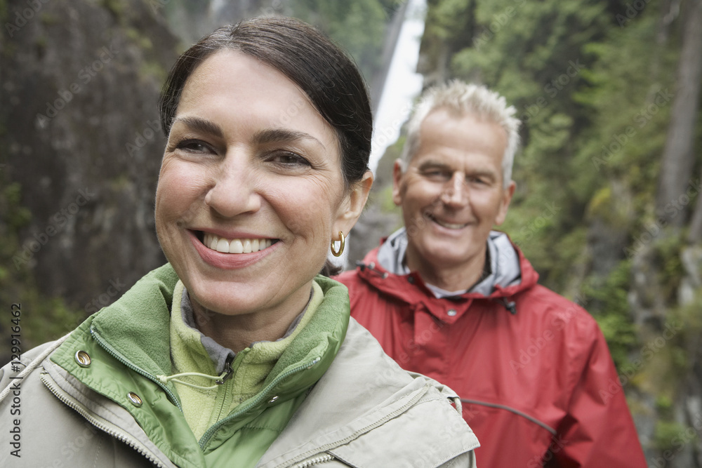 Closeup portrait of a smiling middle aged woman and woman against waterfall Closeup portrait of a smiling middle aged woman and woman against waterfall