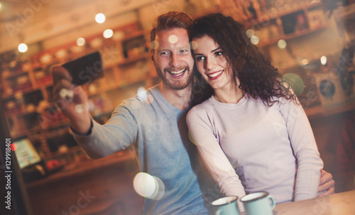 Beautiful couple taking selfie in cafe