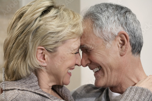 Side view closeup of romantic middle aged couple with heads together