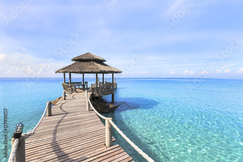Beautiful tropical beach landscape, wooden pier, transparent turquoise sea water