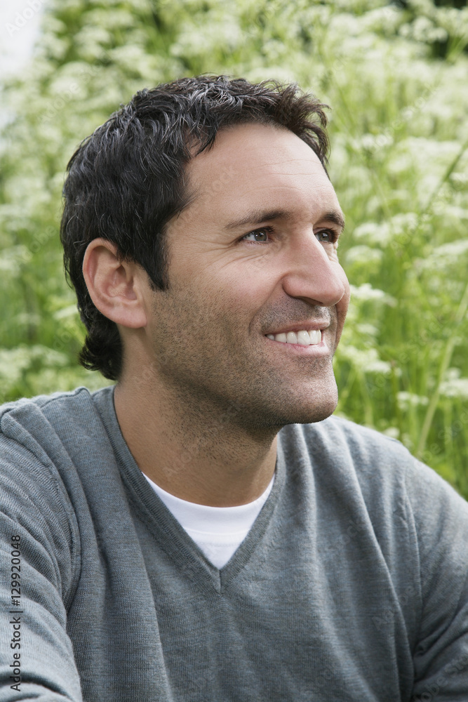 Closeup of a thoughtful smiling man looking away outdoors Closeup of a thoughtful smiling man looking away outdoors