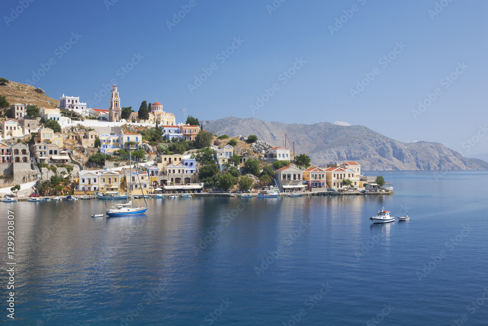 View across the tranquil waters of Harani Bay, Gialos (Yialos), Symi (Simi), Rhodes, Dodecanese Islands, South Aegean, Greece View across the tranquil waters of Harani Bay, Gialos (Yialos), Symi (Simi), Rhodes, Dodecanese Islands, South Aegean, Greece