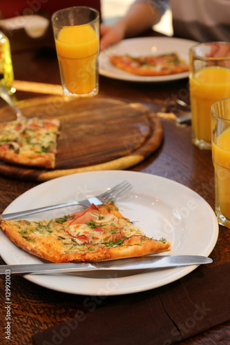 Plate with tasty pizza and glasses of juice on wooden table  close up view