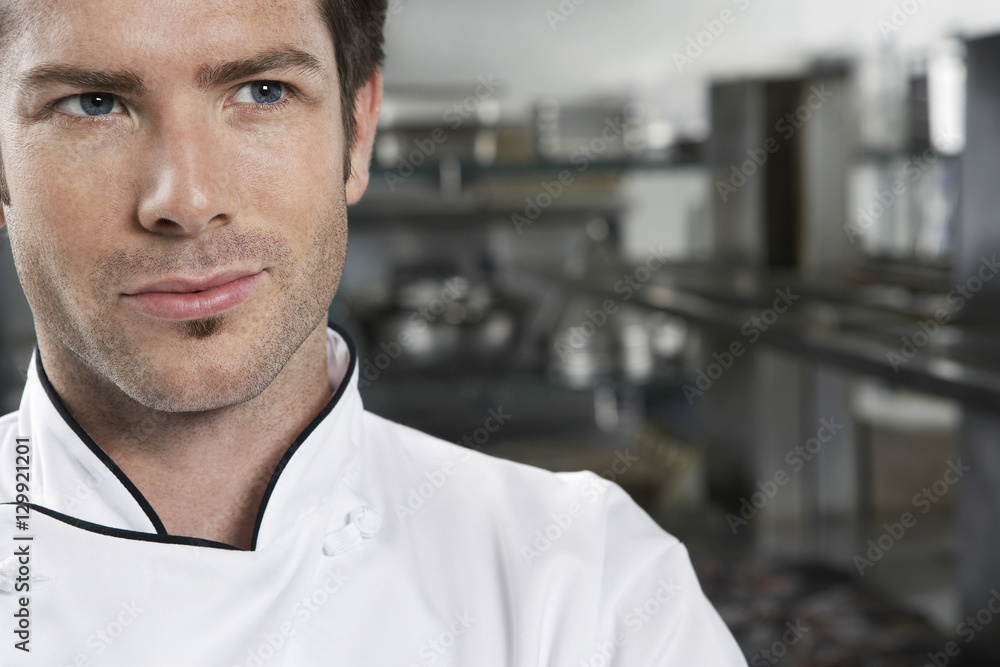 Closeup portrait of a male chef looking away in kitchen Closeup portrait of a male chef looking away in kitchen