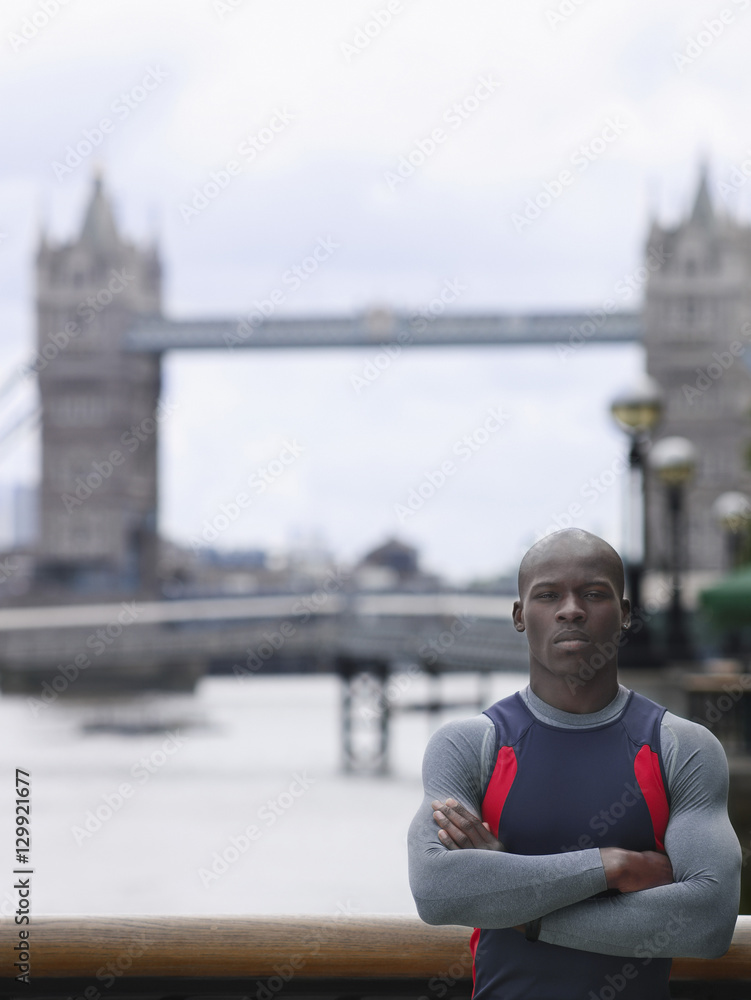 Portrait of a serious young African American man with arms crossed in front of Tower Bridge in England Portrait of a serious young African American man with arms crossed in front of Tower Bridge in England