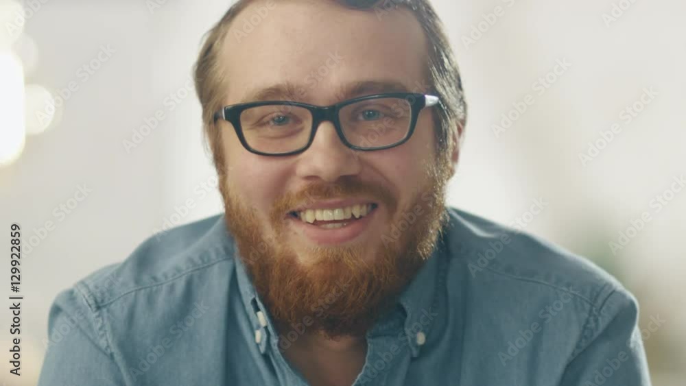 Happy Young Ginger Bearded Man Wearing Glasses Smiles Into the Camera. Bright Lights In the Background. Shot on RED Cinema Camera in 4K (UHD). Happy Young Ginger Bearded Man Wearing Glasses Smiles Into the Camera. Bright Lights In the Background. Shot on RED Cinema Camera in 4K (UHD).