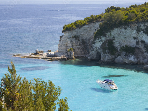 View from hillside over secluded Voutoumi Bay, solitary boat at anchor, Antipaxos, Paxi, Corfu, Ionian Islands, Greek Islands, Greece photo