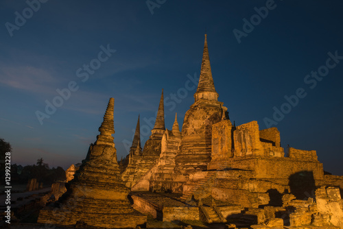 Ancient ruins of the temple Wat Phra Sri Sanphet  national historic site with lights show at twilight time in Ayutthaya, Thailand.