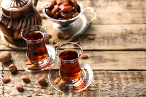 Turkish tea in traditional glasses with nuts on wooden background