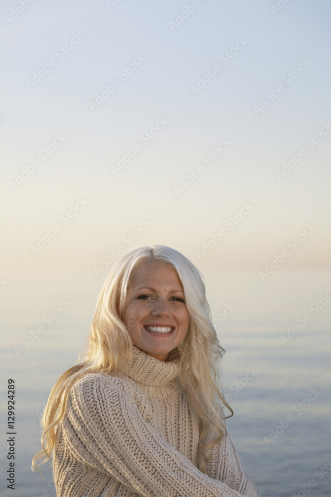 Portrait of beautiful young woman smiling at beach Portrait of beautiful young woman smiling at beach