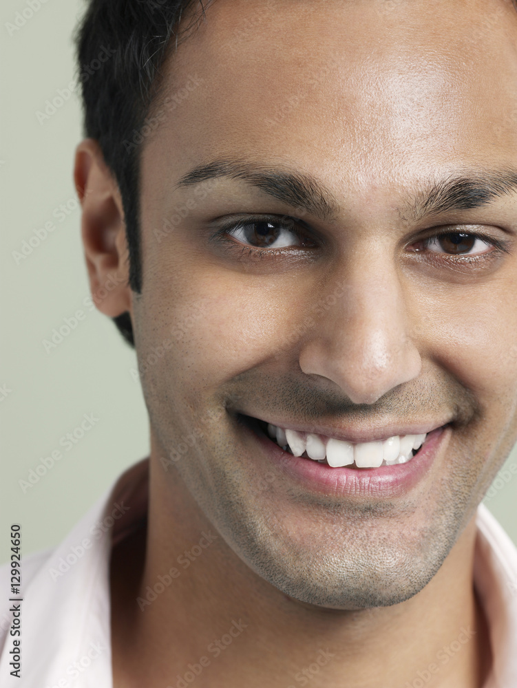 Obraz premium Closeup portrait of handsome young man smiling on colored background