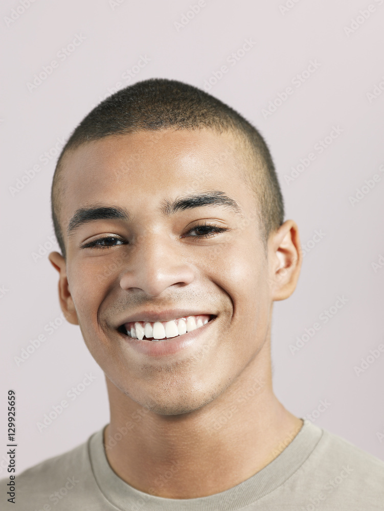 Closeup of young African American man smiling on colored background Closeup of young African American man smiling on colored background