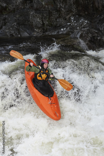 Elevated view of a woman kayaking in rough river