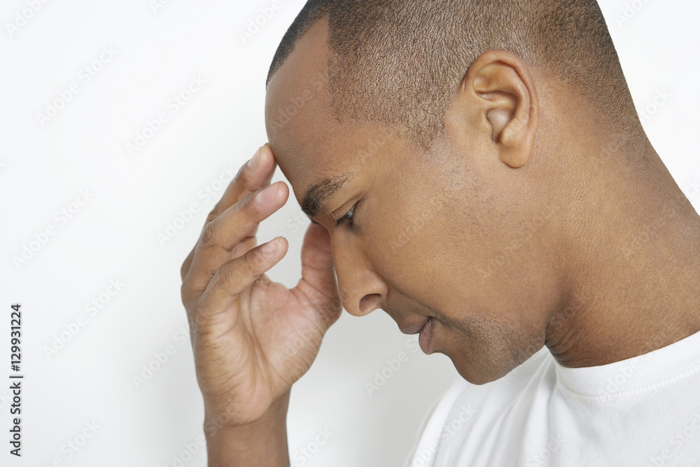 Closeup of an African American man suffering from headache on white background Closeup of an African American man suffering from headache on white background