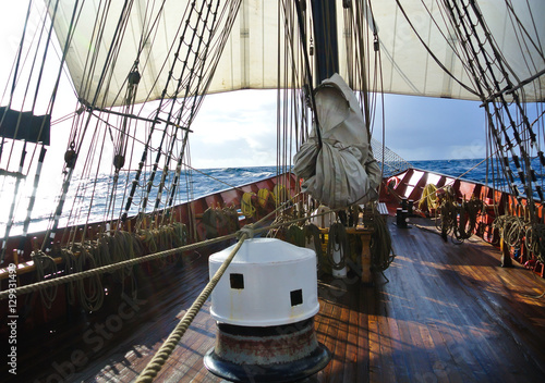 On deck with capstan and sails of a traditional tallship or sailboat