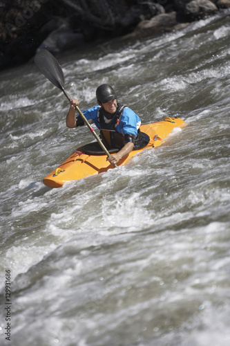 Young Caucasian man kayaking in mountain river © moodboard