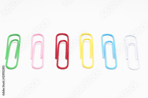 Row of multi colored paper clips over white background