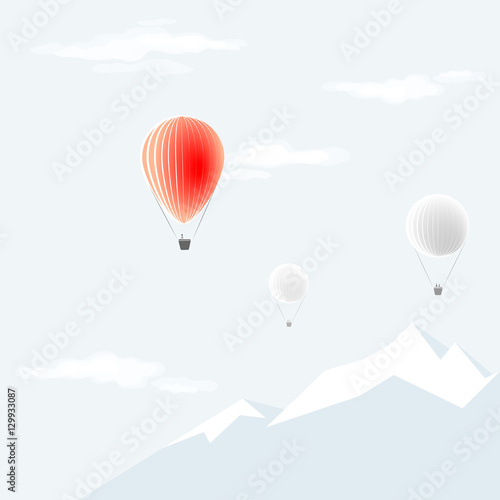 The red hot-air balloon flies on a background of clear sky and mountains
