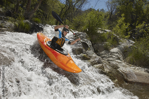 Caucasian man kayaking on mountain river