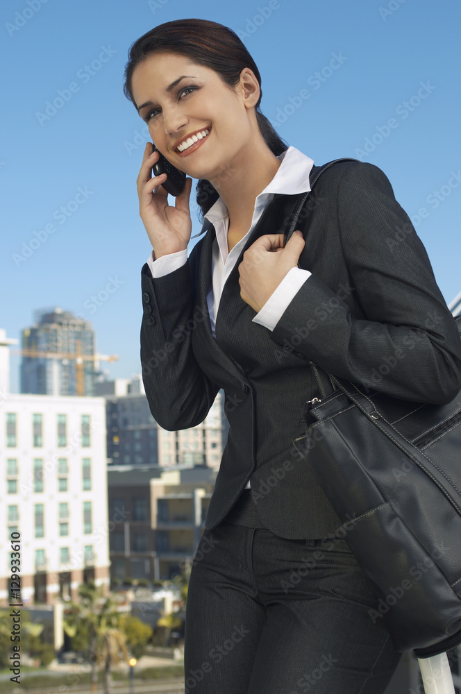Beautiful businesswoman using cell phone outdoors Beautiful businesswoman using cell phone outdoors