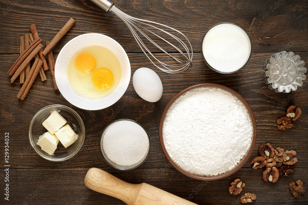 Ingredients for baking cakes with cinnamon and walnuts on the wooden background. Ingredients for baking cakes with cinnamon and walnuts on the wooden background.