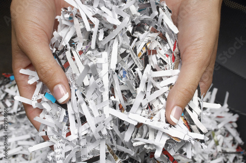 фотографія Closeup of female hands holding heap of shredded papers