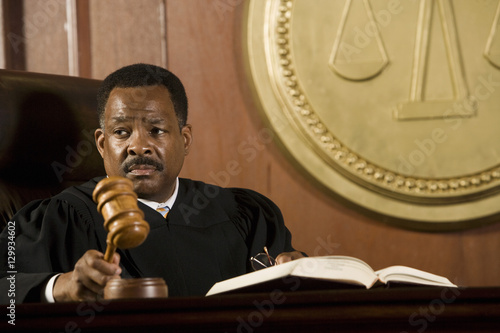 Photo Serious middle aged judge knocking a gavel