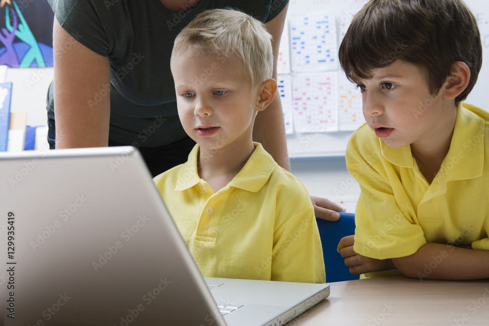 Two schoolboys learning computer technology in classroom Two schoolboys learning computer technology in classroom