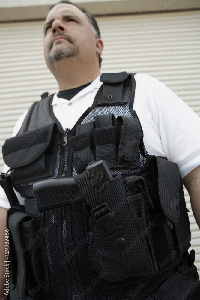 Low angle view of a security guard in bulletproof vest Low angle view of a security guard in bulletproof vest