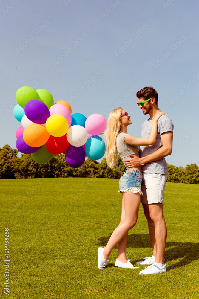 Young happy lovers having date in the park and holding balloons Young happy lovers having date in the park and holding balloons