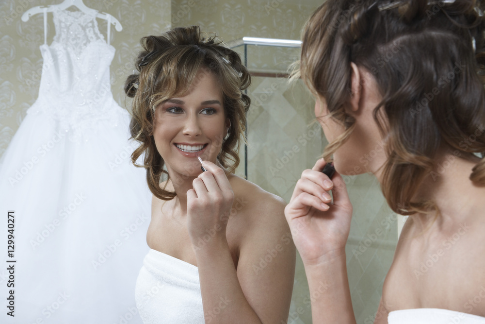 Mirror reflection of bride applying lipstick Mirror reflection of bride applying lipstick