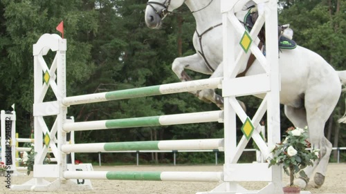 SLOW MOTION: Rider on a white horse competing in equestrian showjumping event