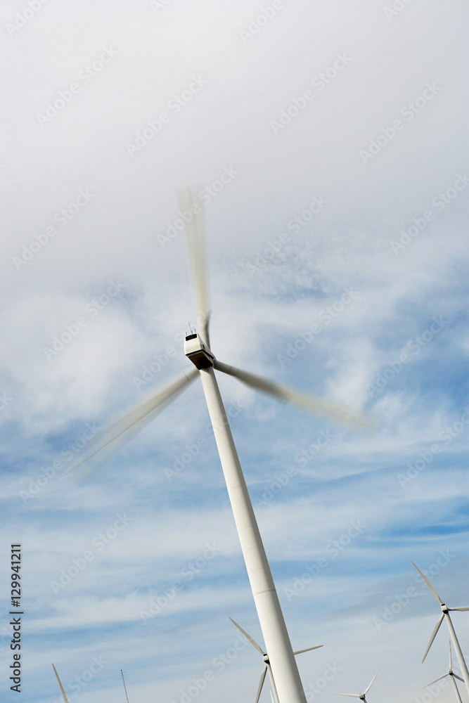 Wind turbine in motion against cloudy sky Wind turbine in motion against cloudy sky