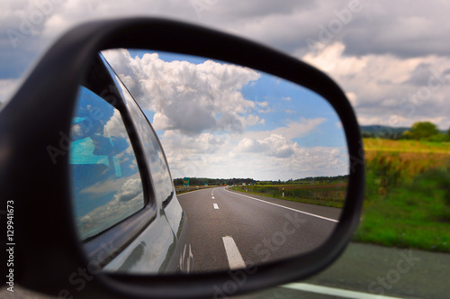 Traveling, rear view mirror road view and clouds