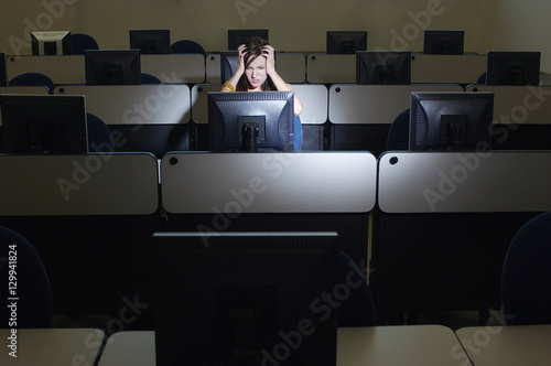 Tablou pe pânză Frustrated young female student using computer in lab