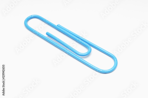 Closeup of blue paperclip over white background