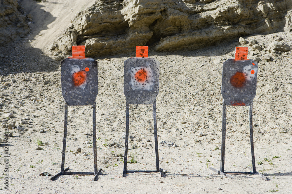 Three targets with bullet holes at firing range Three targets with bullet holes at firing range