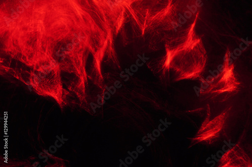 Abstract composition of red smoke in the dark