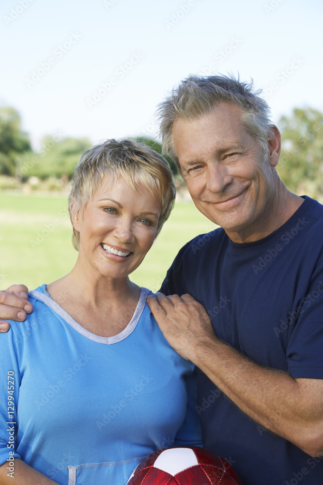Portrait of a happy Caucasian couple with soccer ball in the park Portrait of a happy Caucasian couple with soccer ball in the park