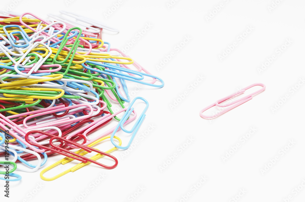 Multicolored heap of paperclips over white background Multicolored heap of paperclips over white background