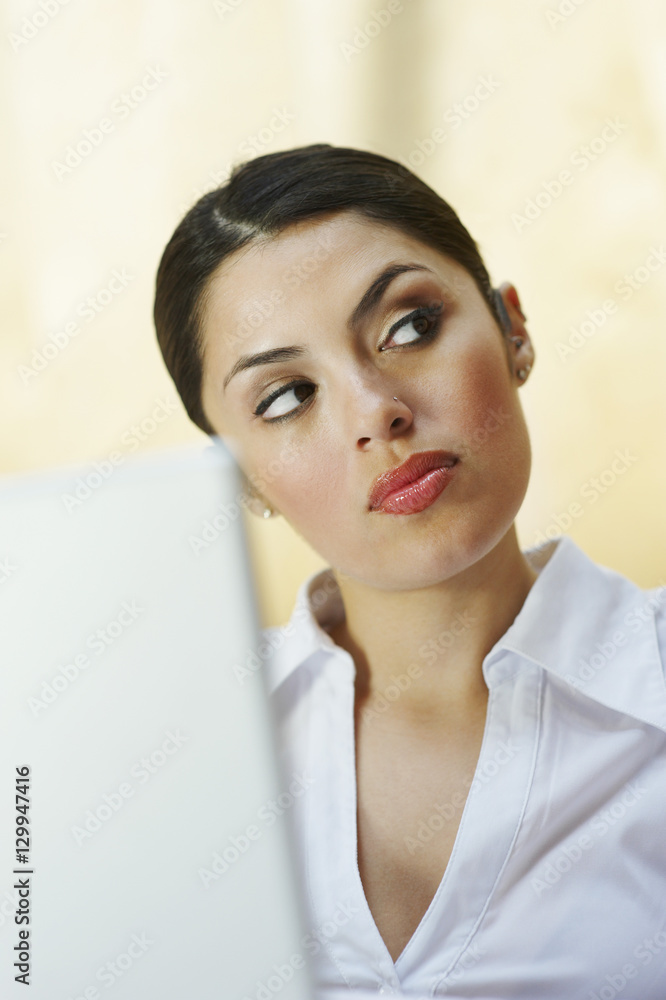 Beautiful business woman looking away with laptop in front Beautiful business woman looking away with laptop in front