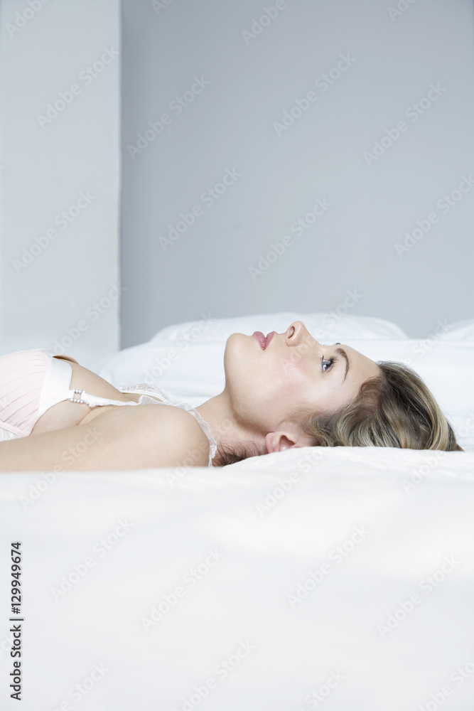 Thoughtful of sensuous young woman lying in bed Thoughtful of sensuous young woman lying in bed