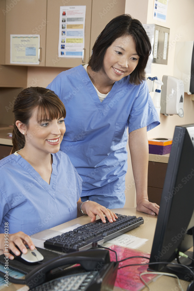 Two female nurses working on computer in doctor's office Two female nurses working on computer in doctor's office