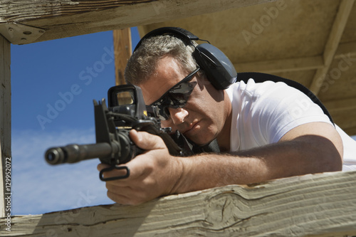 Caucasian man aiming machine gun at firing range