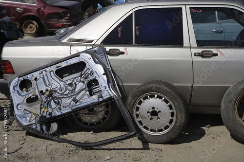 Car with broken vehicle door at junkyard