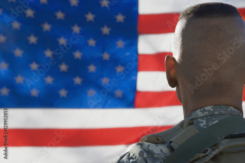 Rear view of US army soldier looking at the American flag