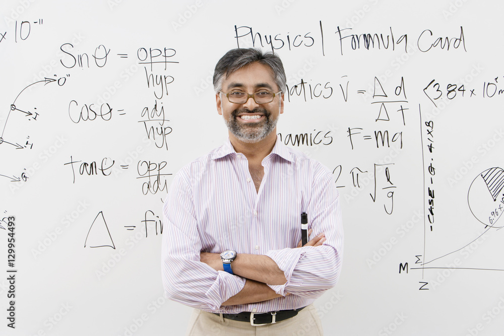 Portrait of a male lecturer standing with arms crossed against white board Portrait of a male lecturer standing with arms crossed against white board