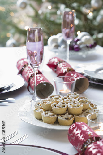 Christmas crackers  champagne flutes and mince pies on dining table
