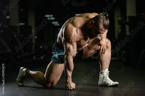 Brutal strong bodybuilder athletic men pumping up muscles with d