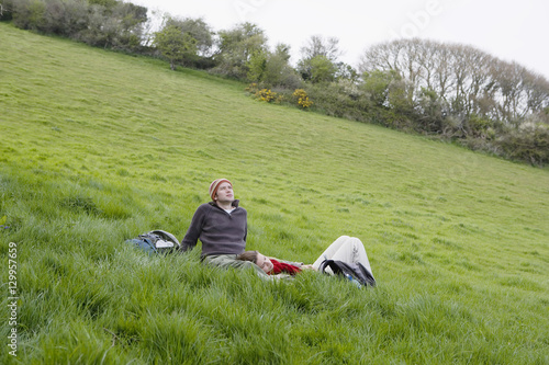 Young hiking couple relaxing on grass